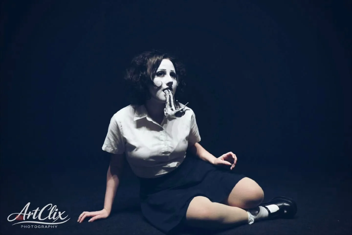 dizzyfr0st’s black-and-white character makeup against a dark blue portrait background