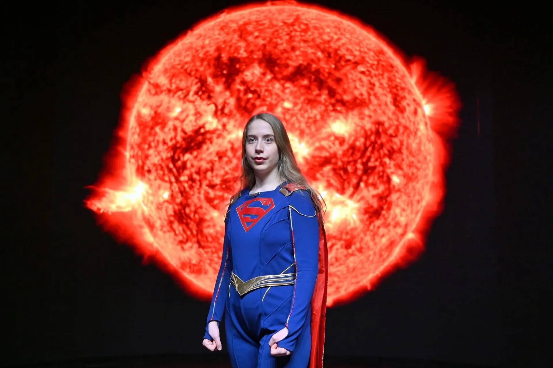 Wide Supergirl portrait with a bright red solar backdrop