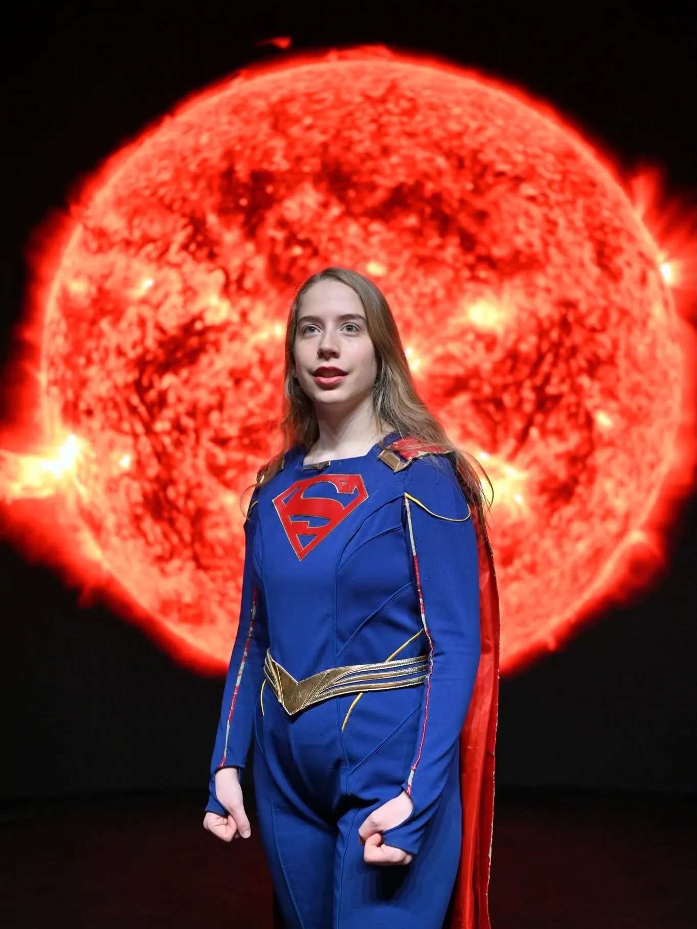 @playfullyjil as Supergirl against a red solar LED background