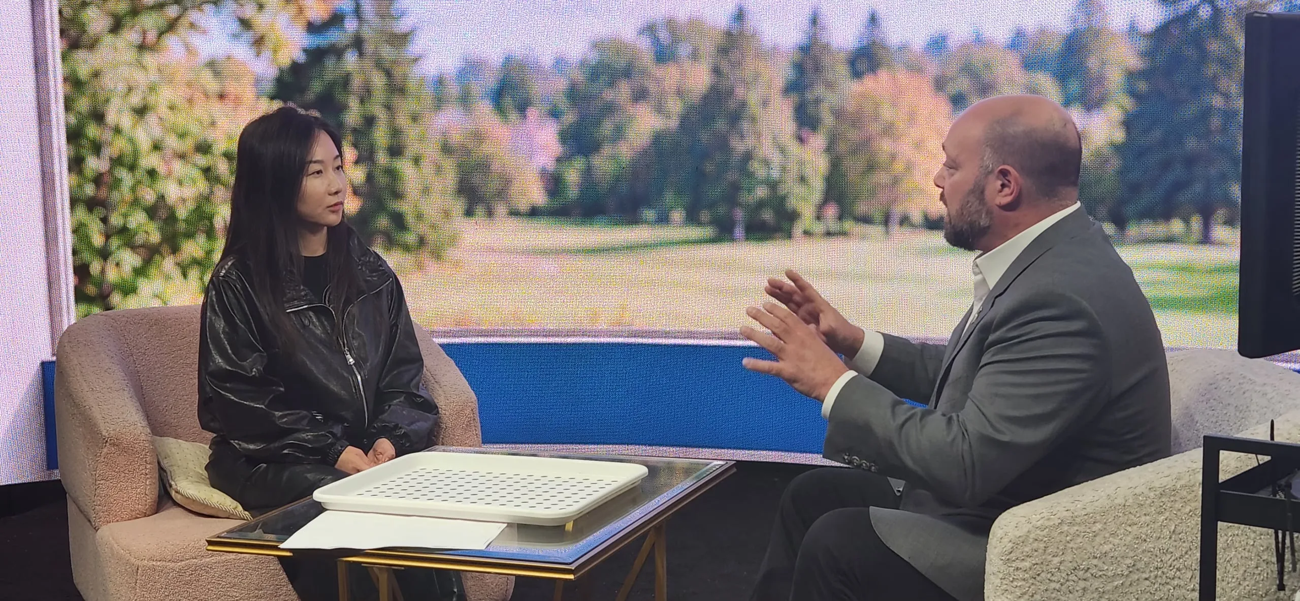 Jaime Stein speaking with Sarah Yu against the LED landscape
