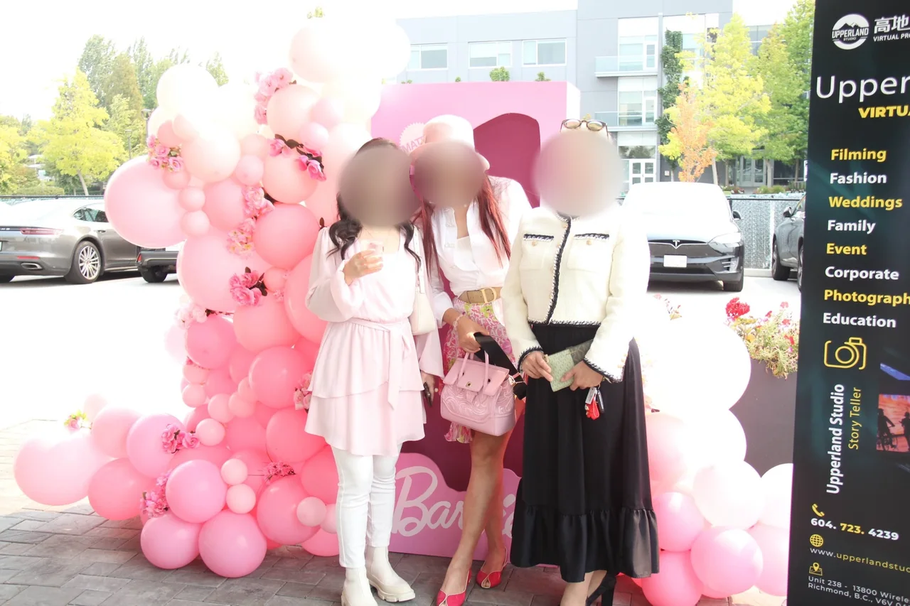 Guests at the pink balloon arch and Barbie photo box at the studio entrance