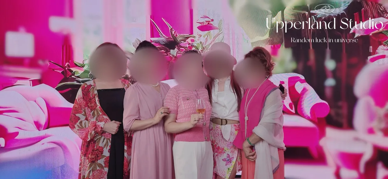 Five women posing before a pink floral LED wall with Upperland Studio watermark