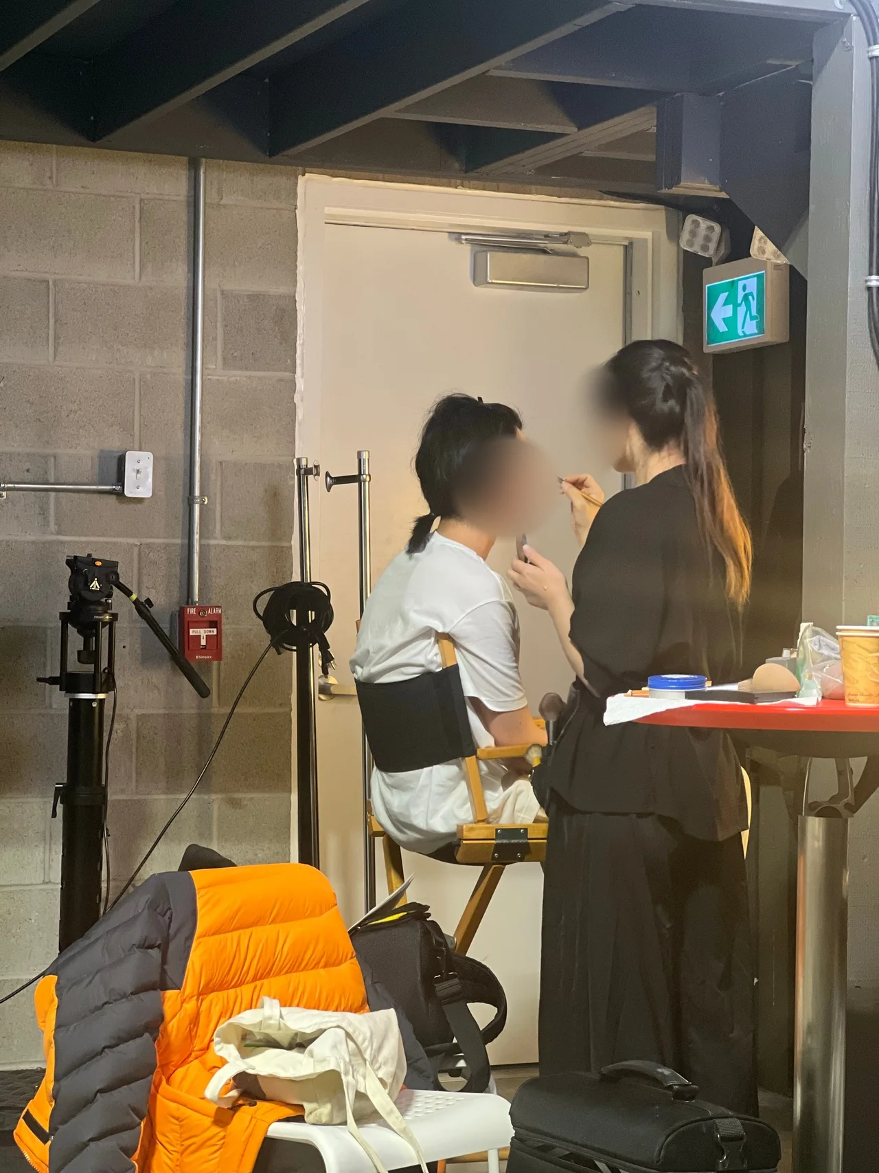 Makeup artist applying makeup to a young male model before the shoot