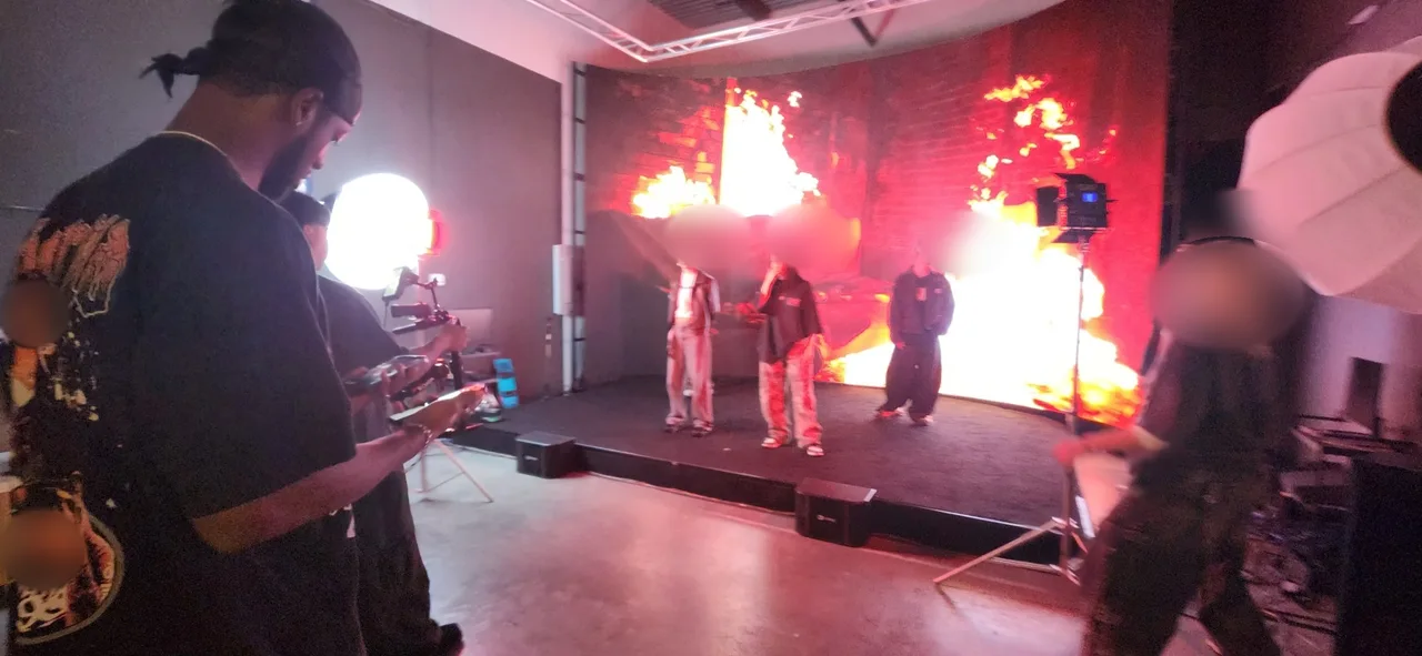 Crew and camera filming three dancers against the fire backdrop
