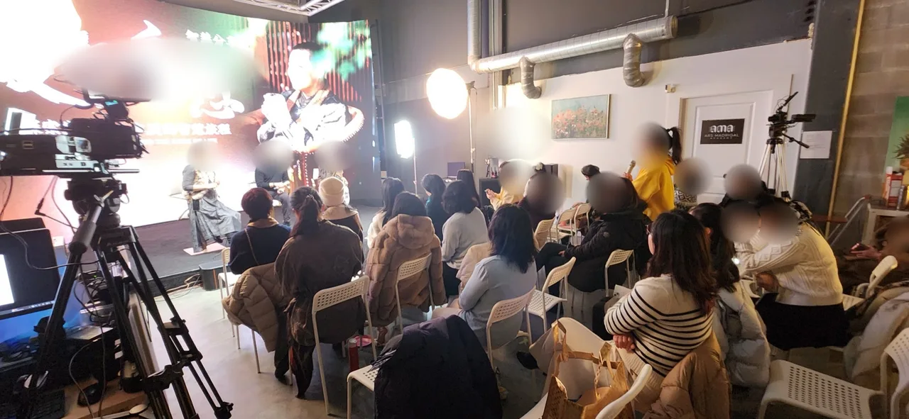 Audience members asking a question during a Chinese parenting talk at Upperland Studio, Richmond BC, with the LED wall showing a calligraphy poster behind the stage