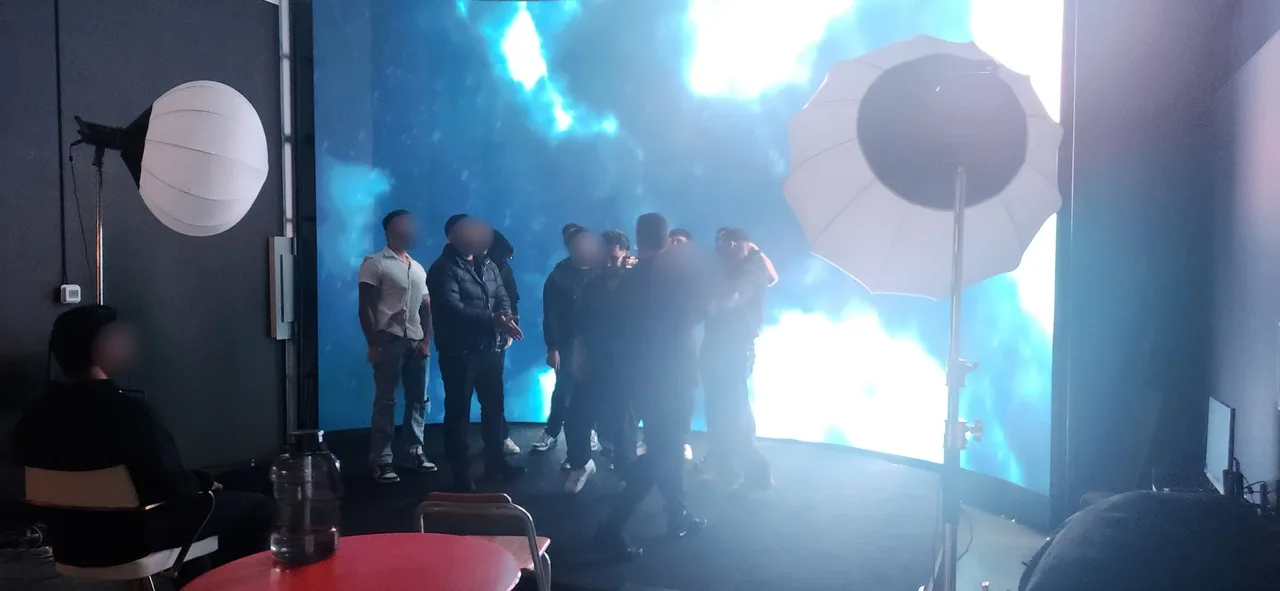 Punjabi performers and crew gathered on stage in front of a blue flame LED wall backdrop at Upperland Studio, Richmond BC