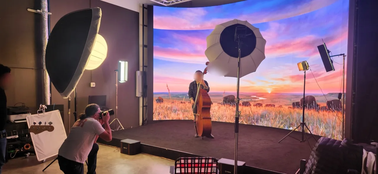 Photographer shooting an upright bass player in front of a prairie bison sunset backdrop on the LED wall at Upperland Studio, Richmond BC