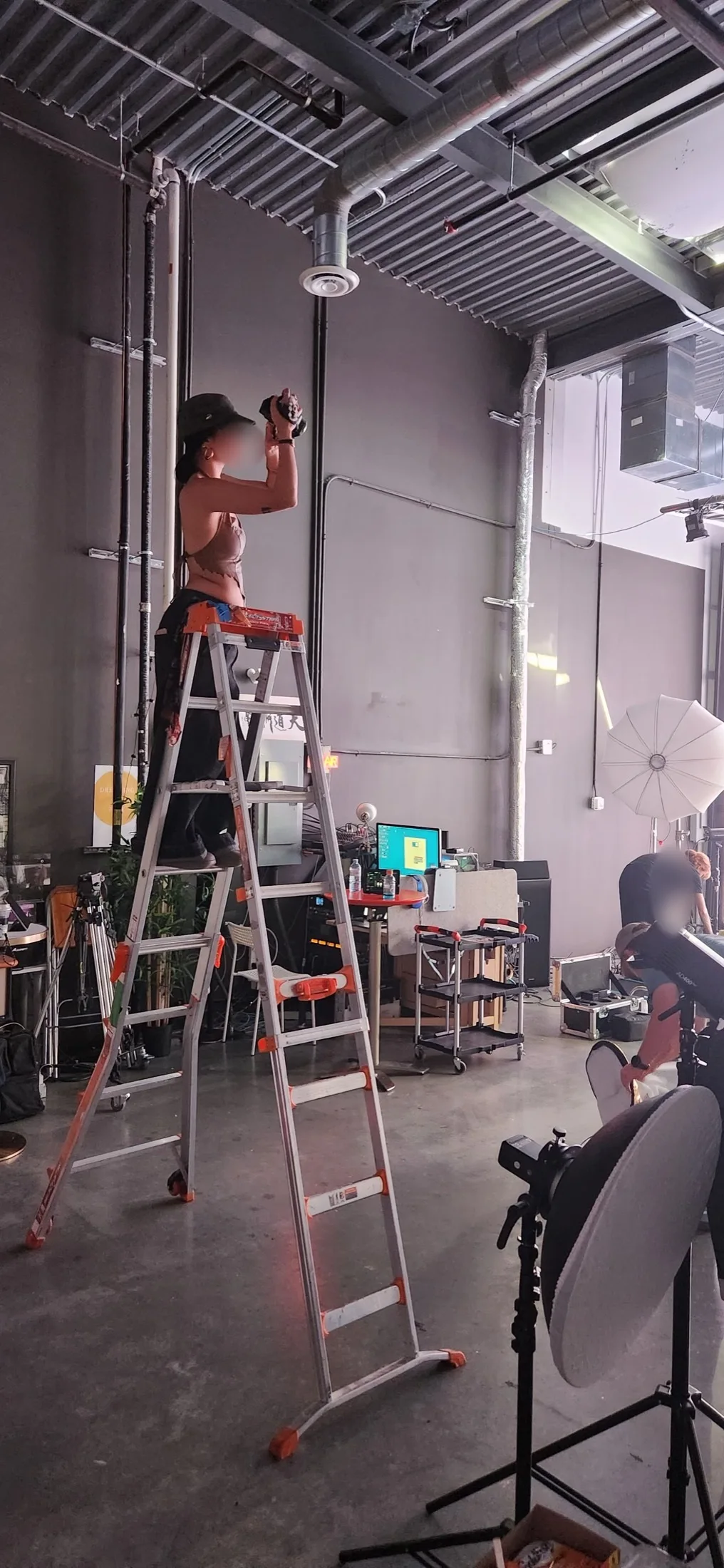 Behind-the-scenes photo of a videographer shooting from a ladder during the music video music video shoot at Upperland Studio, Richmond BC