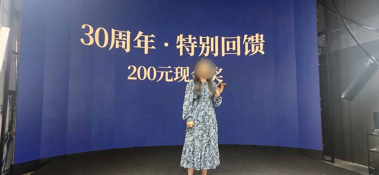 Host speaking in front of a "30th Anniversary Special" backdrop on the LED wall at Upperland Studio, Richmond BC