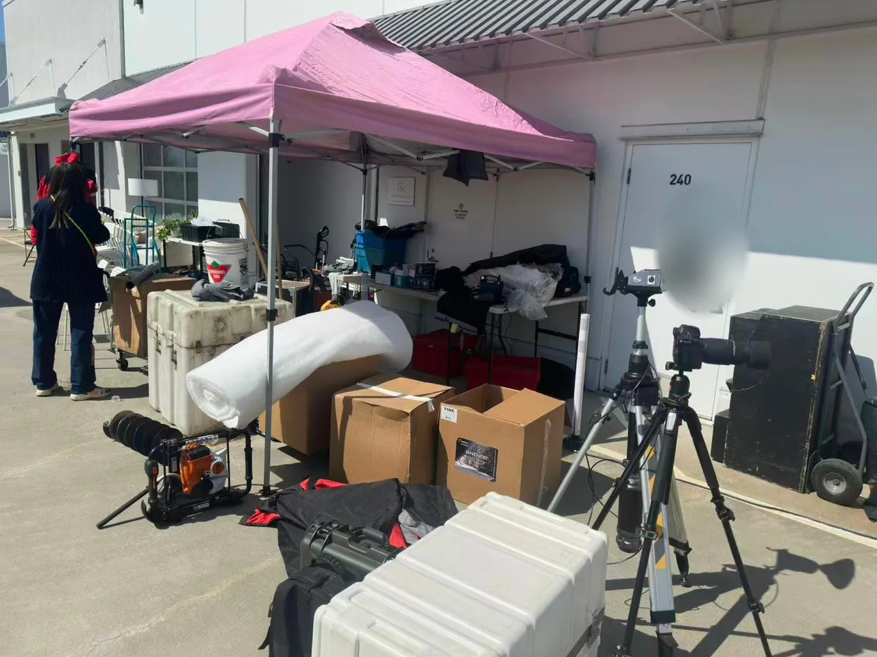 Exterior equipment base with a pink canopy and camera tripods during the Flyover Canada production